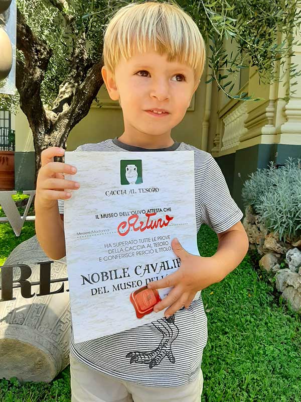 Bambino con diploma del Museo dell Olivo dei Fratelli Carli