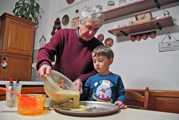 nonno e nipote preparano farinata genovese